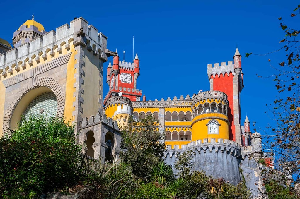 Kulturreise 2027 nach Sintra – Palácio da Pena mit bunter Fassade in Gelb und Rot unter blauem Himmel