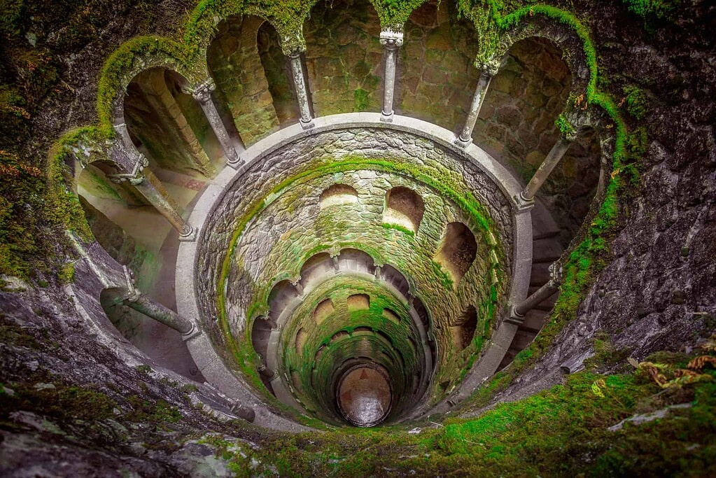 KULTURZELT REISEN 25 Initiationsbrunnen in der Quinta da Regaleira in Sintra – mystischer Schacht mit spiralförmigen Arkaden und Moosbewuchs