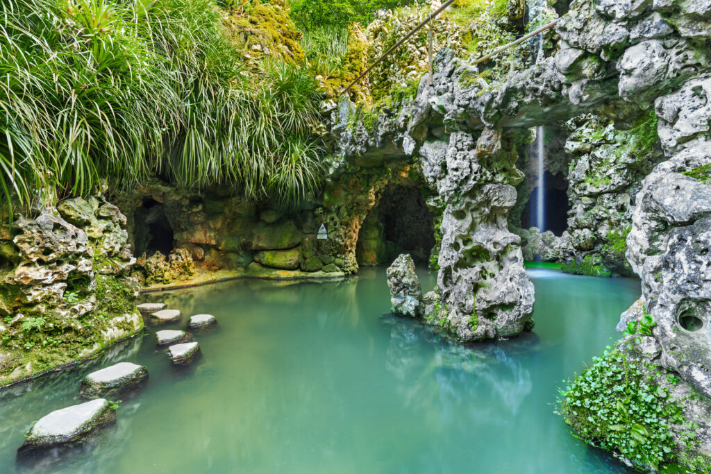 Reise Programm Sintra 2027 15 Trittsteine im türkis schimmernden Grottenteich der Quinta da Regaleira in Sintra — Kulturzelt Reisen Kultur- und Gartenreise Portugal