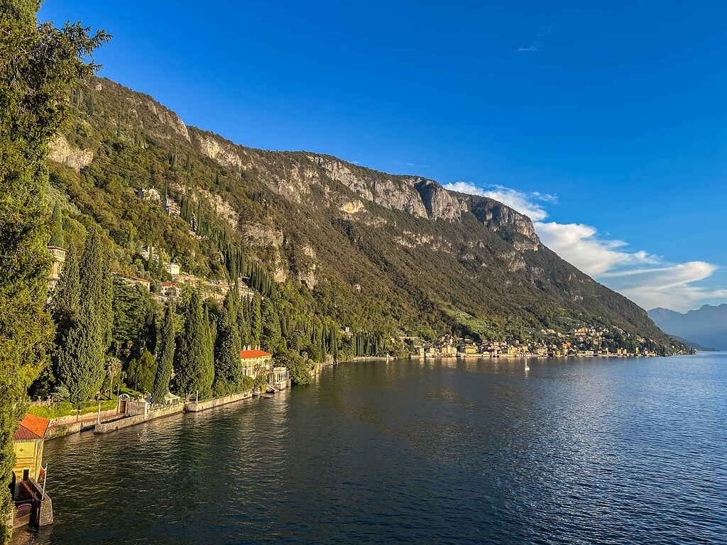 Comersee über die Reise 2026 10 Steiluferlandschaft am Comersee mit Villen am Hang, Zypressen und schroffen Felsen, Blick über das Wasser zu den Bergen – Kulturzelt Reisen Kultur- und Gartenreise Comersee 2027