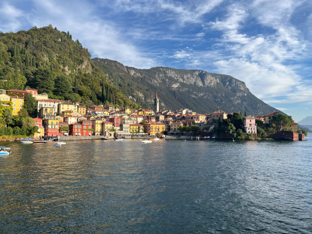 Reise Programm Comersee 2026 9 Blick vom Wasser auf Varenna am Comersee mit bunt gefärbten Häusern, der Kampanile von San Giorgio und den schroffen Felsen des Sasso – Kulturzelt Reisen Kultur- und Gartenreise Comersee 2026