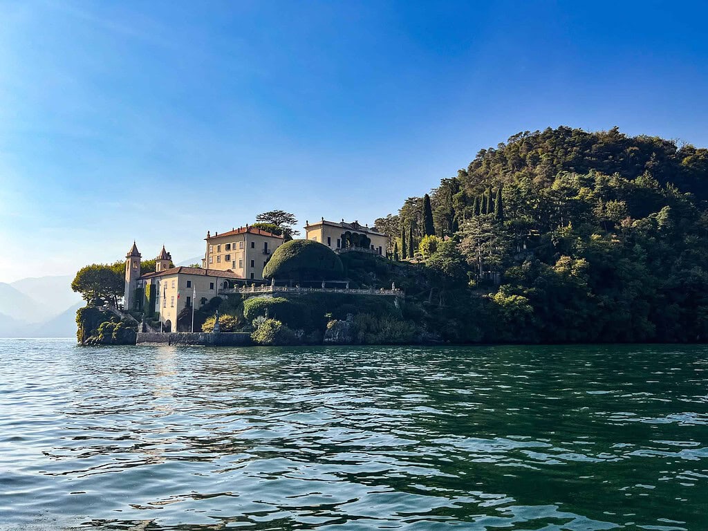 Comersee über die Reise 2026 7 Seitenansicht der Villa del Balbianello vom Comersee aus mit Kapelle, Loggia Durini und der bewaldeten Halbinsel – Kulturzelt Reisen Kultur- und Gartenreise Comersee 2027