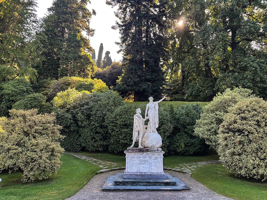 Comersee über die Reise 2026 12 Marmorskulptur 'Dante und Beatrice' im Park der Villa Melzi in Bellagio am Comersee, eingerahmt von geschnittenen Buchsbaumkugeln – Kulturzelt Reisen Kultur- und Gartenreise Comersee 2027