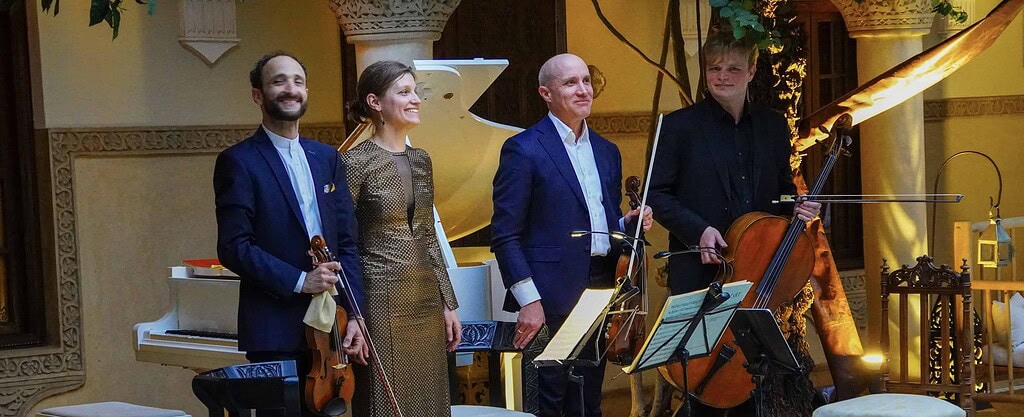 KULTURZELT REISEN 14 Pianistin, Geiger, Bratschist und Cellist verneigen sich nach dem Konzert im Innenhof eines Riads, im Hintergrund ein weisser Flügel